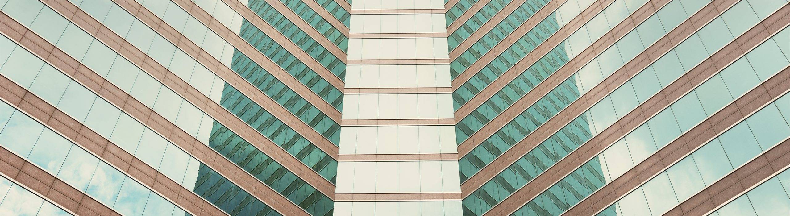 Symmetrical modern building facade with glass and stone lines